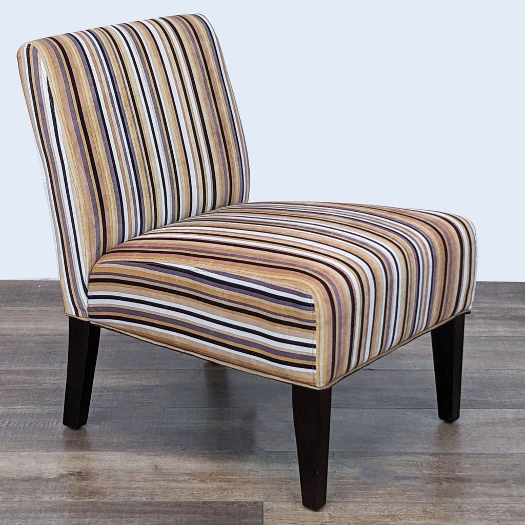 Three-quarter view of a Reperch multi-colored striped fabric slipper chair with padded back and seat.