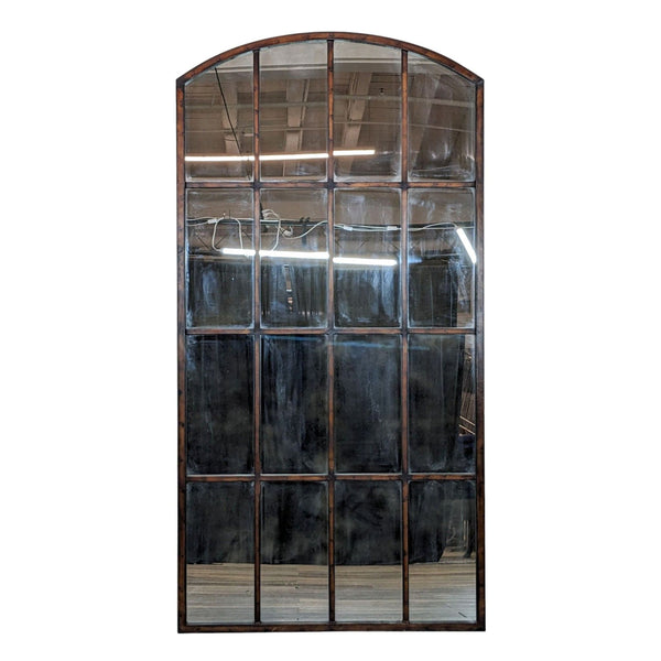 Arched top mirror with paneled design by Uttermost, displayed against an indoor background.