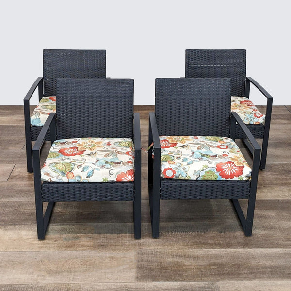 Black wicker armchairs with colorful cushions by Reperch, front angled view.