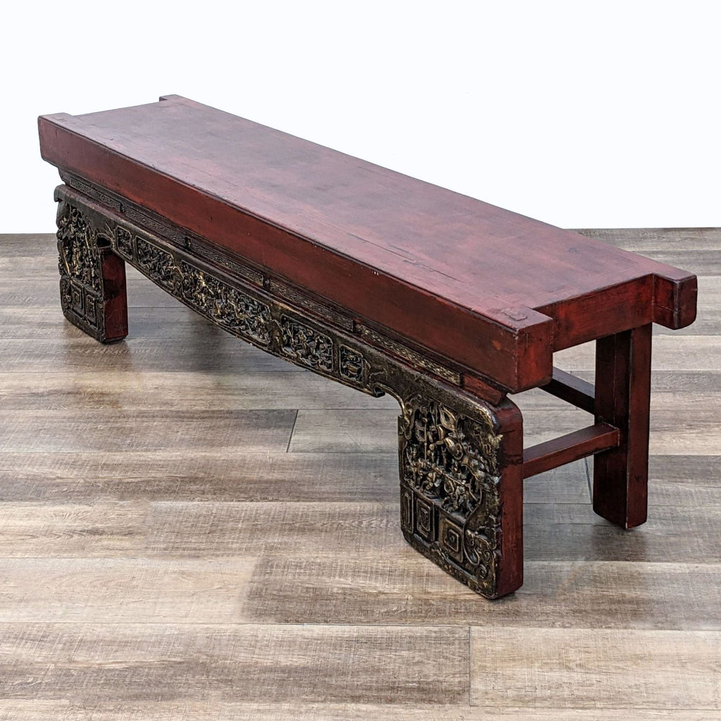 3. "Angled perspective of a 79" Asian Opium long bench by Madera Home, with gold detailed carvings on the legs, placed on a hardwood floor."