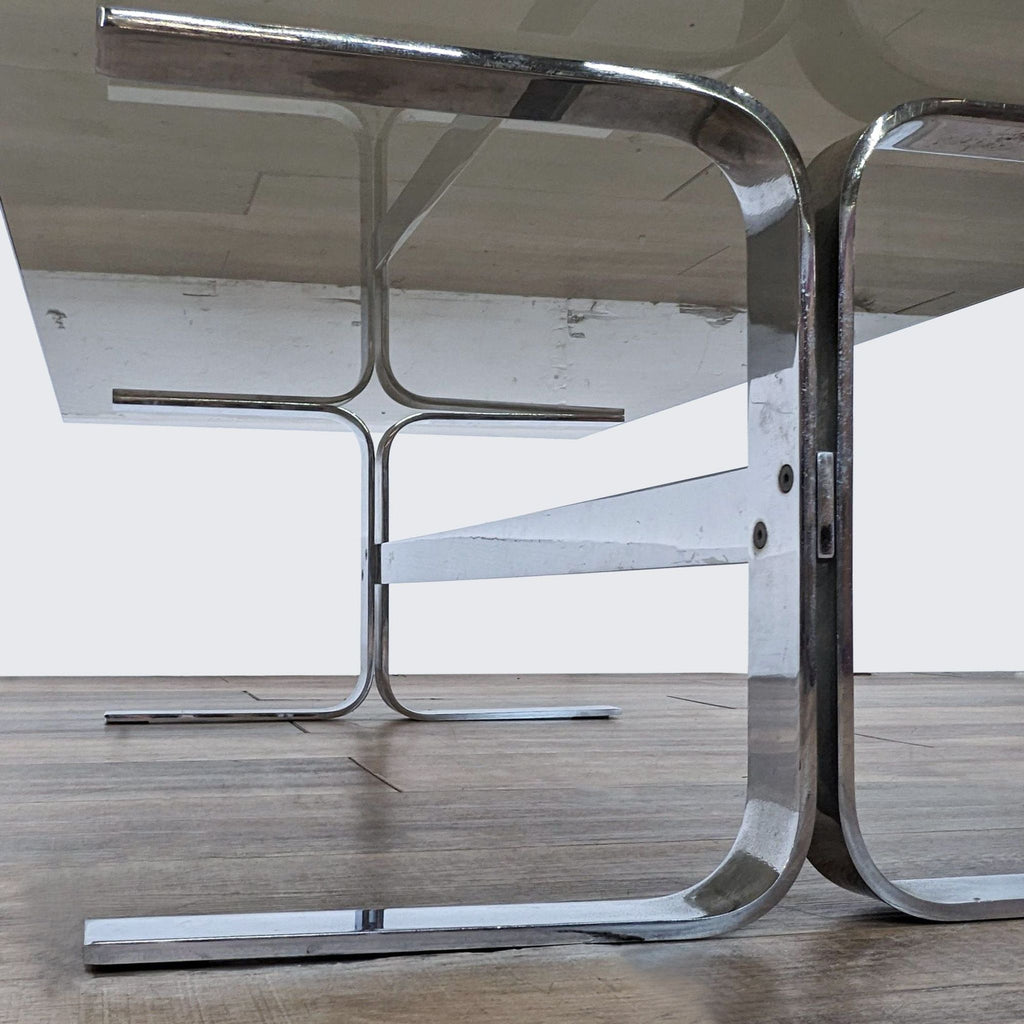 Close-up of Reperch trestle coffee table's stainless steel base, showcasing its sleek, modern design.