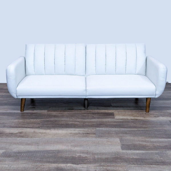 Alt text 1: A white Dorel Home Furnishings Brittany futon in upright position with tufted back, faux leather upholstery, and wooden legs on a wooden floor.