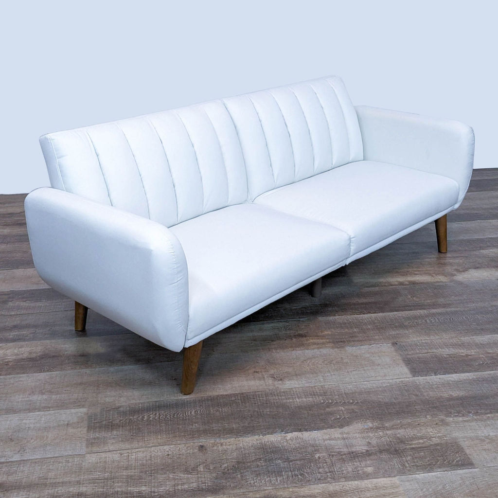 Alt text 3: Slanted view of a white 3-seat Brittany futon by Dorel Home Furnishings with curved armrests and angled wood legs, in lounge position.