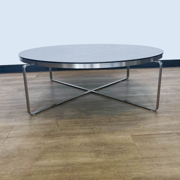 1. "Reperch brand coffee table with a sleek metal base and a round, light-grey tabletop, set on a wooden floor."