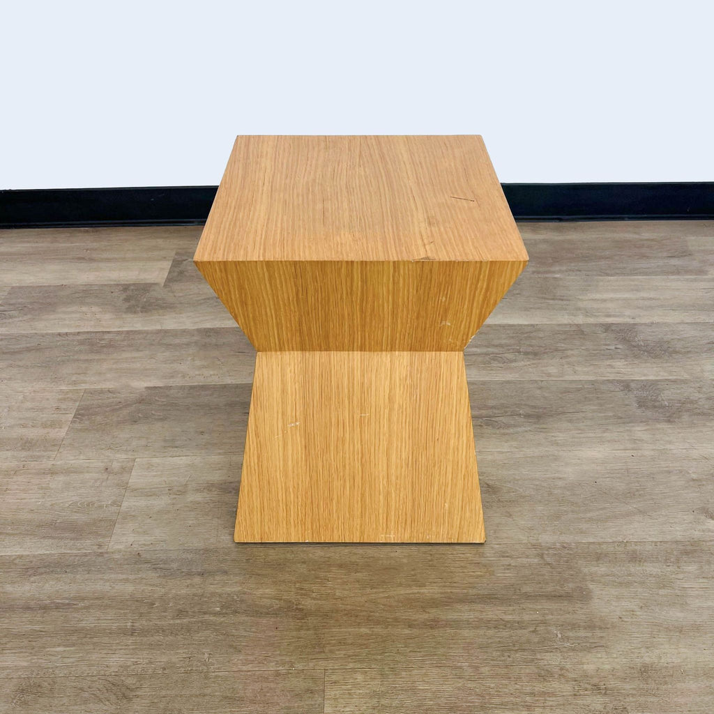 2. Modern Reperch console table with a symmetrical, hourglass-shaped wooden body, set on a wooden floor.