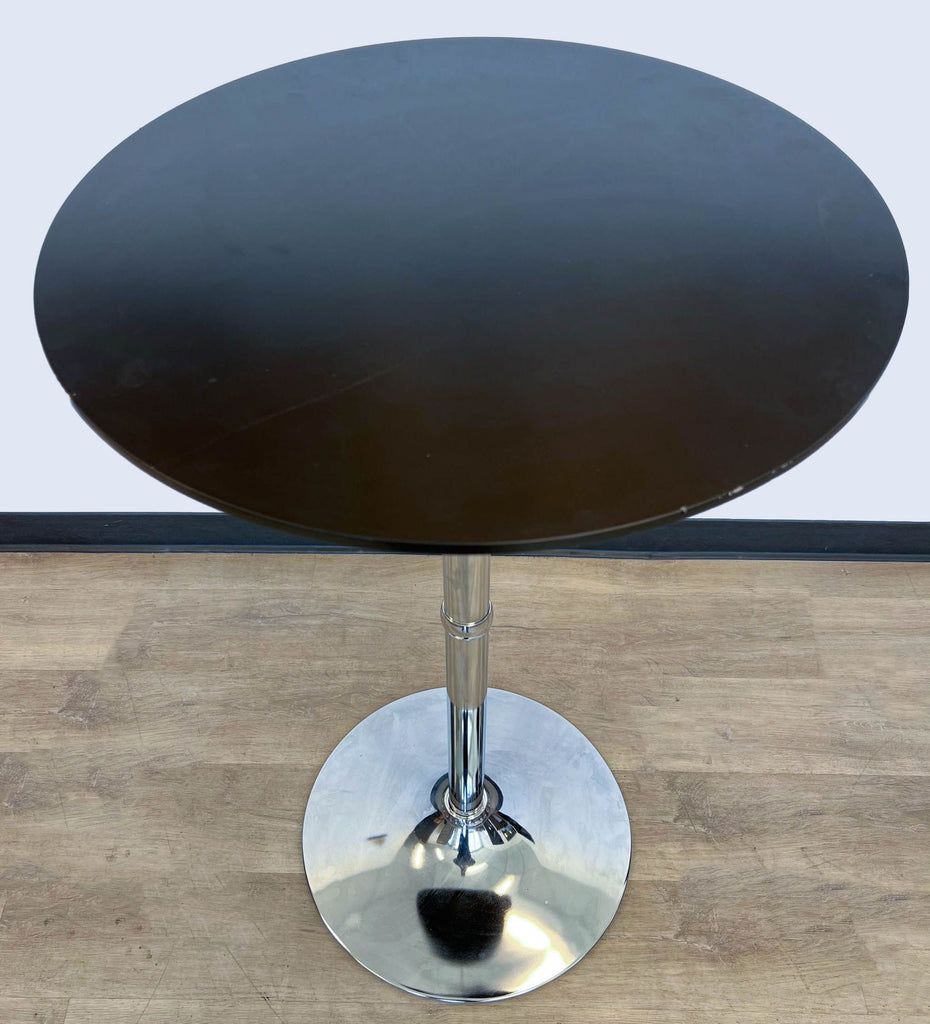 Top-down view of Reperch bar height table with round wooden top and metallic stand.
