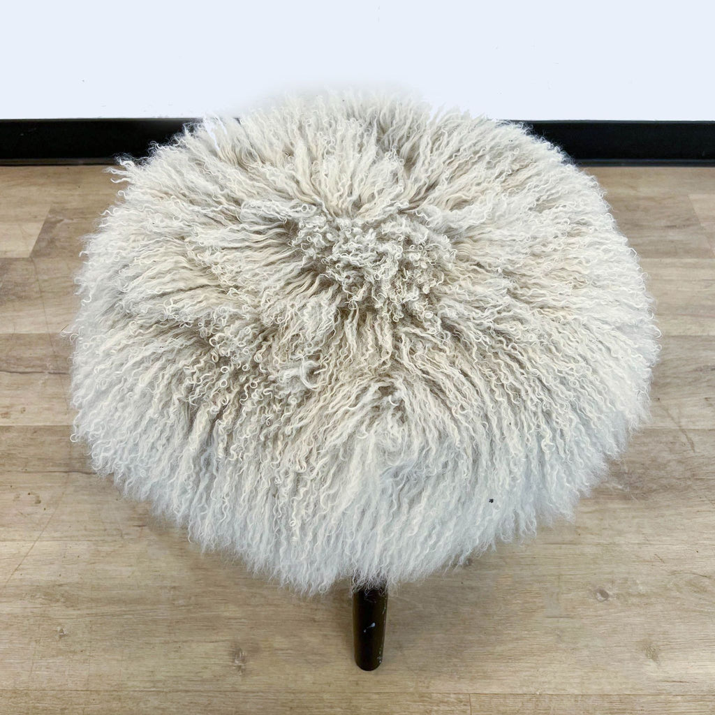 2. Top view of a small, circular shaggy fur stool by Reperch, showcasing the texture and round shape, on a light wood floor.