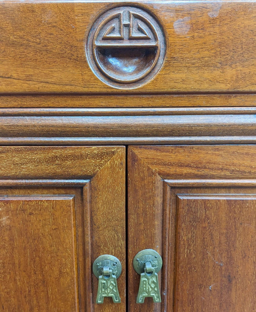 Close-up of Reperch end table showing intricate handle details, wooden texture, symbol emblem, from Hong Kong.