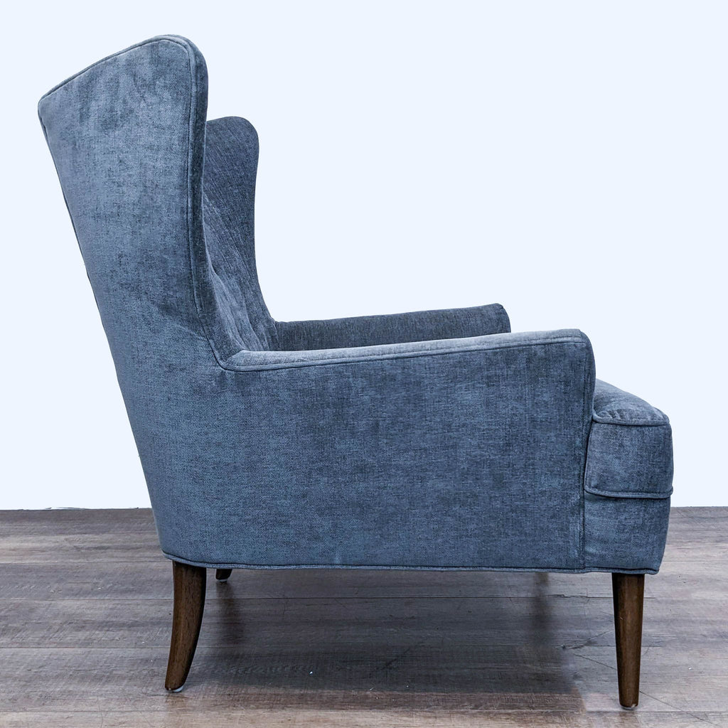 2. Side angle view showcasing the tapered wooden legs and wingback design of the Four Hands Clermont lounge chair.