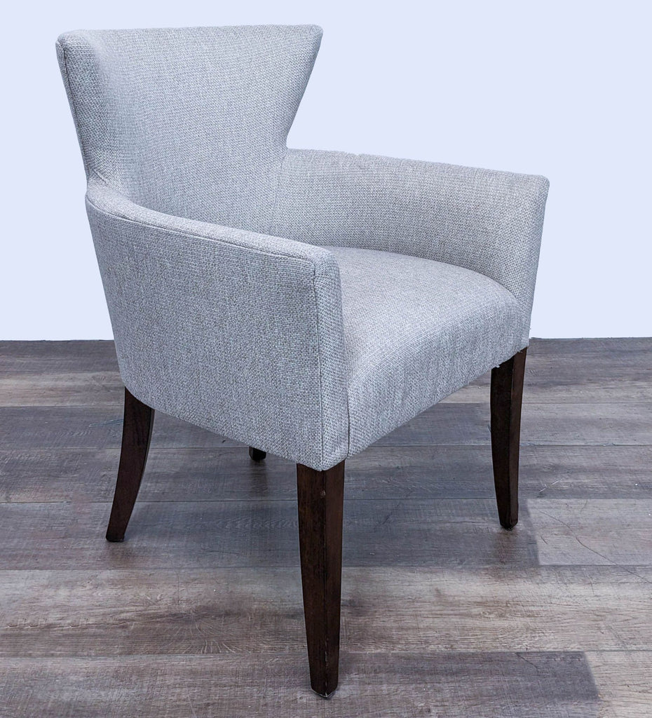 Three-quarter view of a contemporary Reperch lounge chair with an upholstered wingback design and tapered legs.