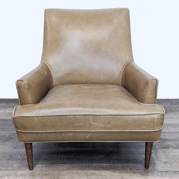 1. Front view of a mid-century styled Danya wing chair by Four Hands, featuring molded curves, upholstered in soft leather, on tapered wood legs.