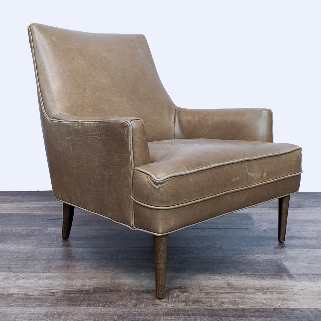2. Angled side view of the Danya wing chair by Four Hands, showcasing its mid-century design, soft leather upholstery, and tapered wooden legs.