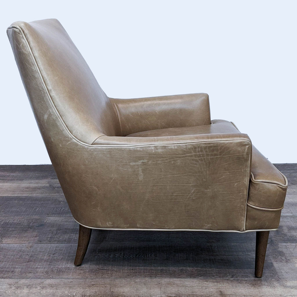 3. Rear angled perspective of a leather-upholstered Danya wing chair with mid-century shaping and tapered wooden legs from Four Hands.