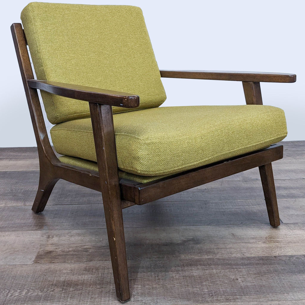 Three-quarter view of the World Market Xander chair, highlighting the mid-century modern style, solid wood construction, and yellow-green cushions.