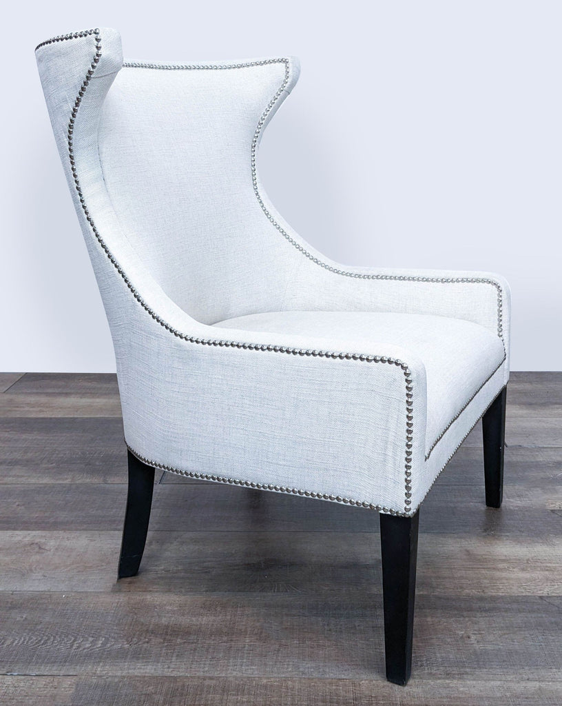 Three-quarter angle of a Reperch white upholstered chair, featuring comfortable cushioning and elegant nailhead trim.