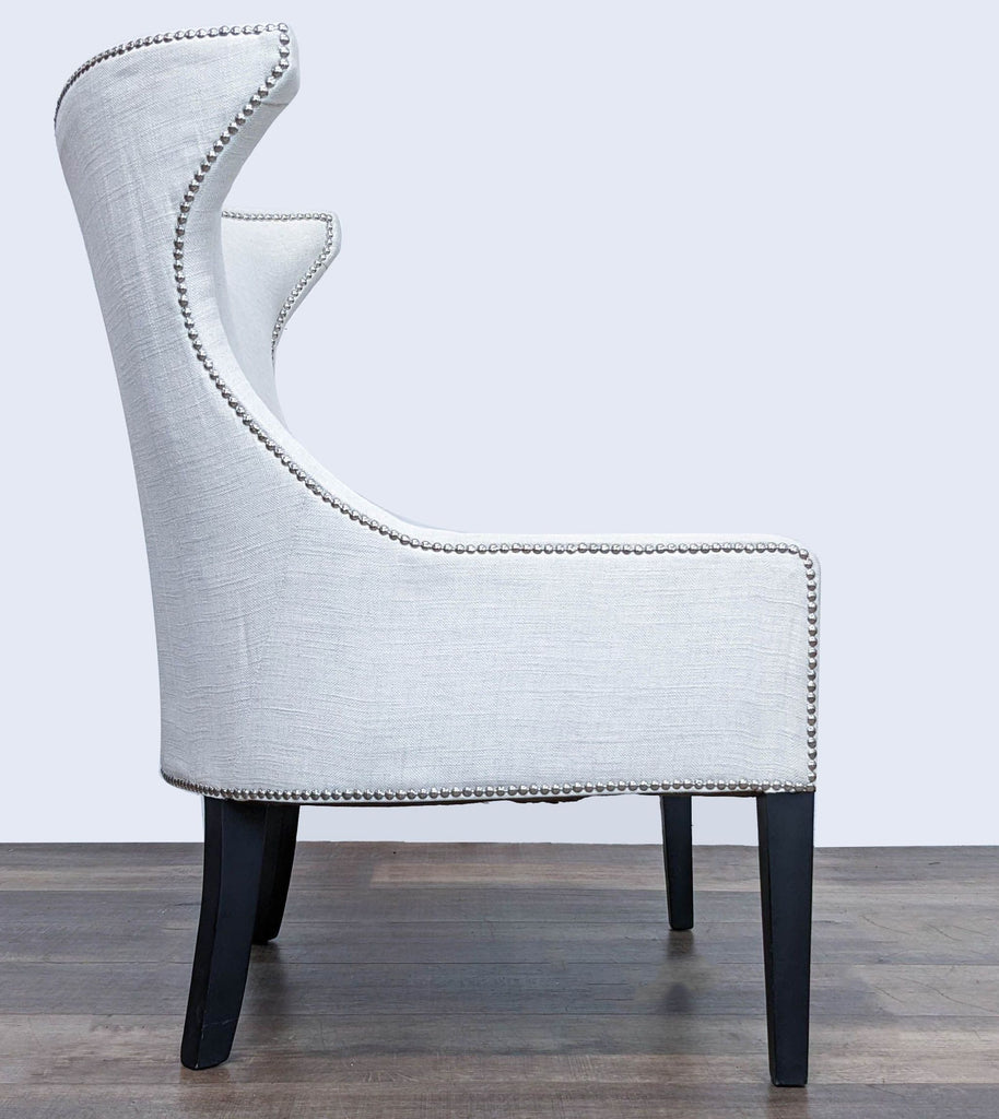 Side view of a Reperch white fabric chair with high back and nailhead accents, showcasing the curved silhouette.