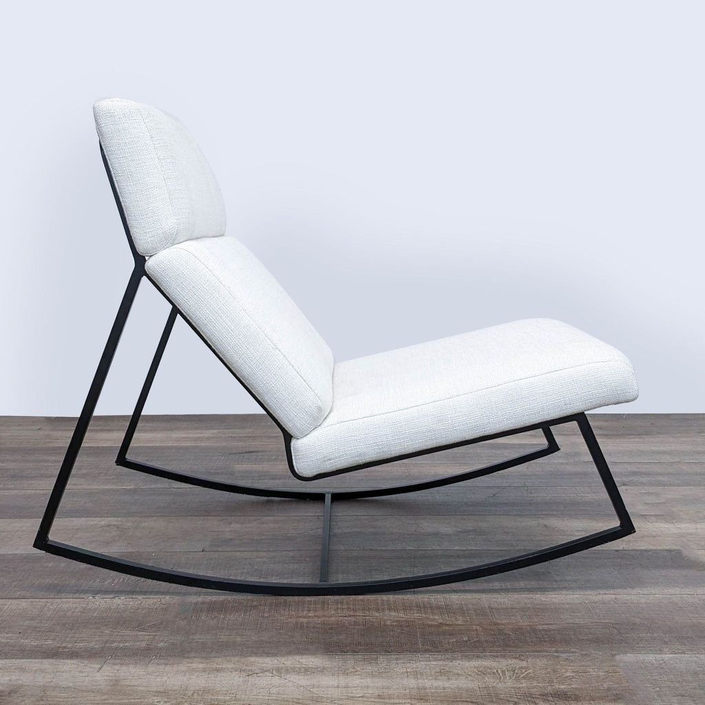 2. Side view of a Gus Modern lounge chair showing the unique rocking frame design and textured, grey fabric.