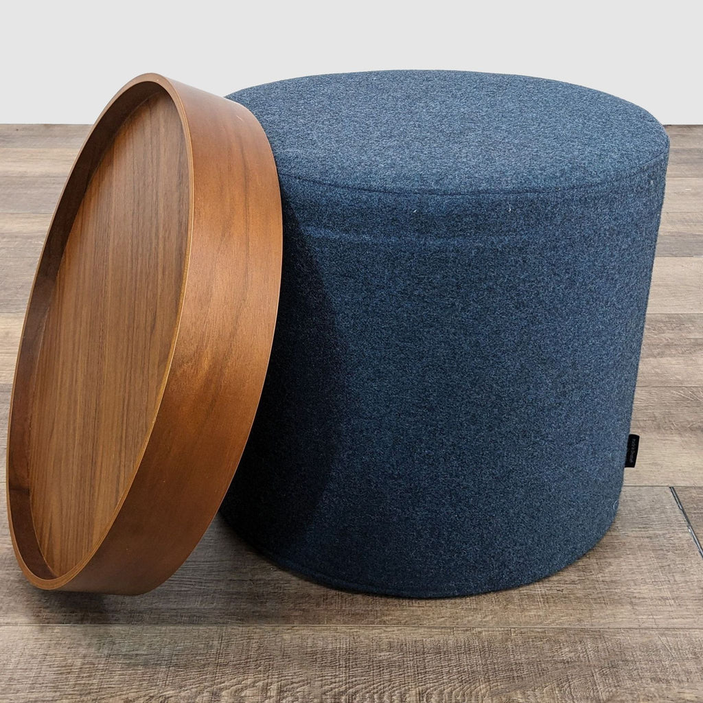 2. Angled view of a wood-topped coffee table with the circular tray slightly tilted to reveal a cylindrical fabric base.
