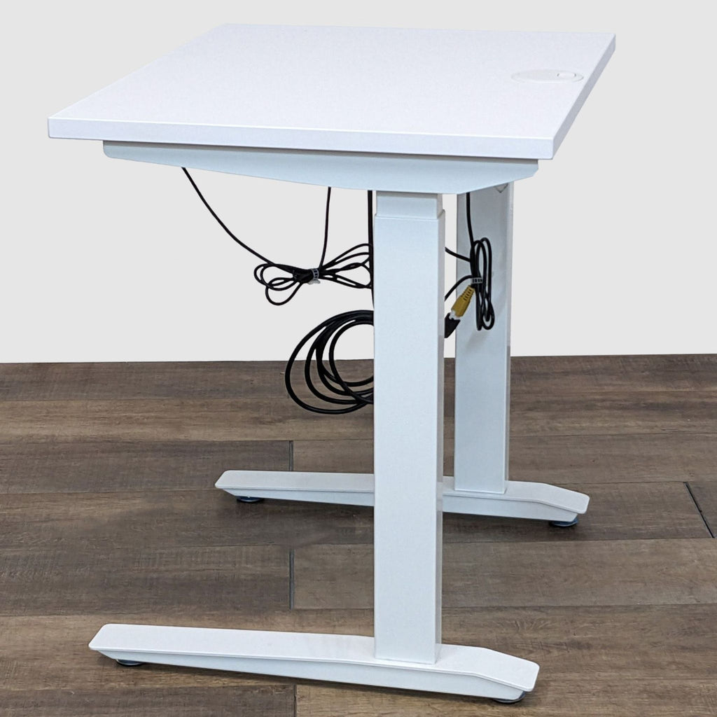 Alt text 3: Angled view of a white electric standing desk by Fully showing the desk's profile and cable management.