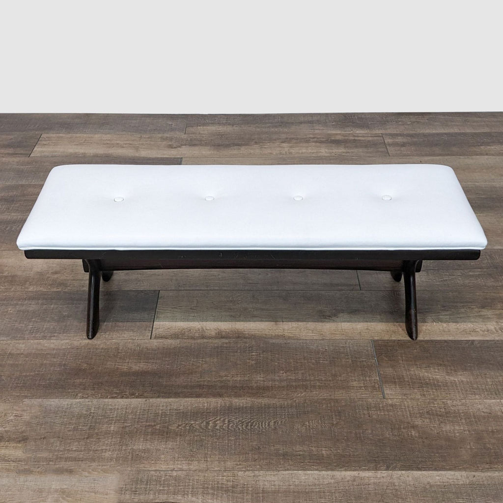 Reperch white leather-look tufted bench on a dark frame, front view on wooden floor.