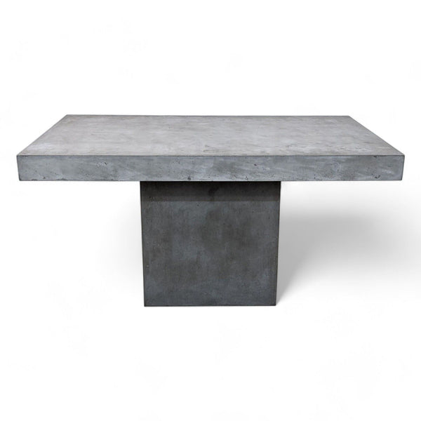 CB2 Fuze dining table with industrial chic style, made of stone composite and natural fibers on a white background.