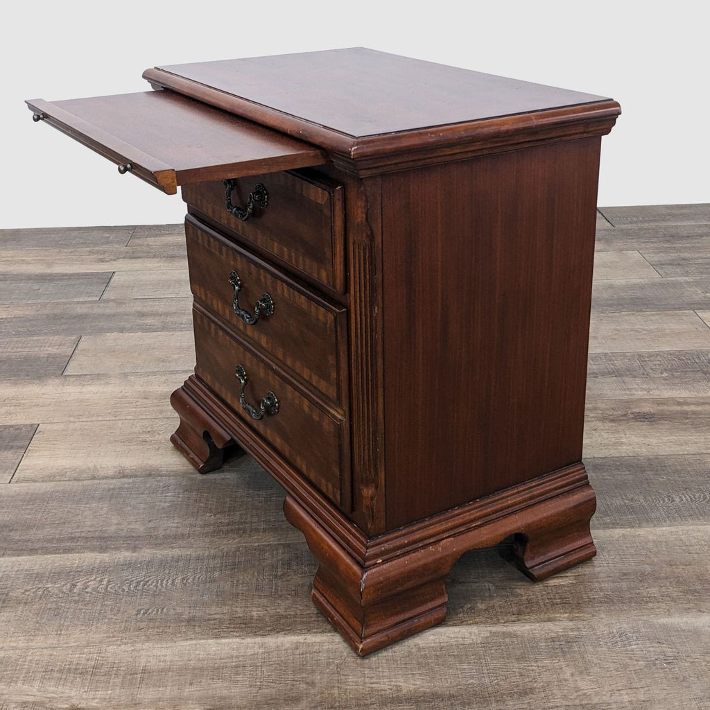 Reperch end table with pull-out tray extended, showcasing traditional carving and brown finish on wood floor.