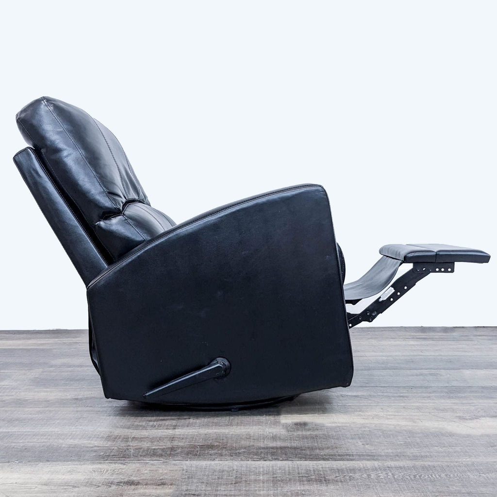 Side view of reclined black leather chair with extended footrest.  