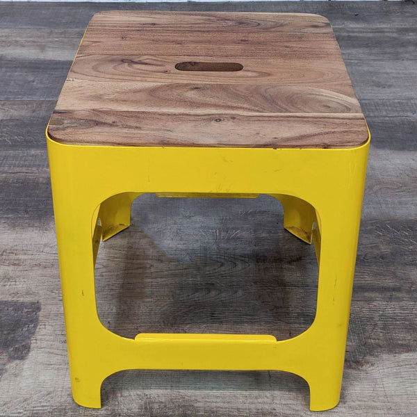 Alt text 1: A Reperch 14-inch square stool with a vibrant yellow metal base and solid wood top, viewed from an angle.