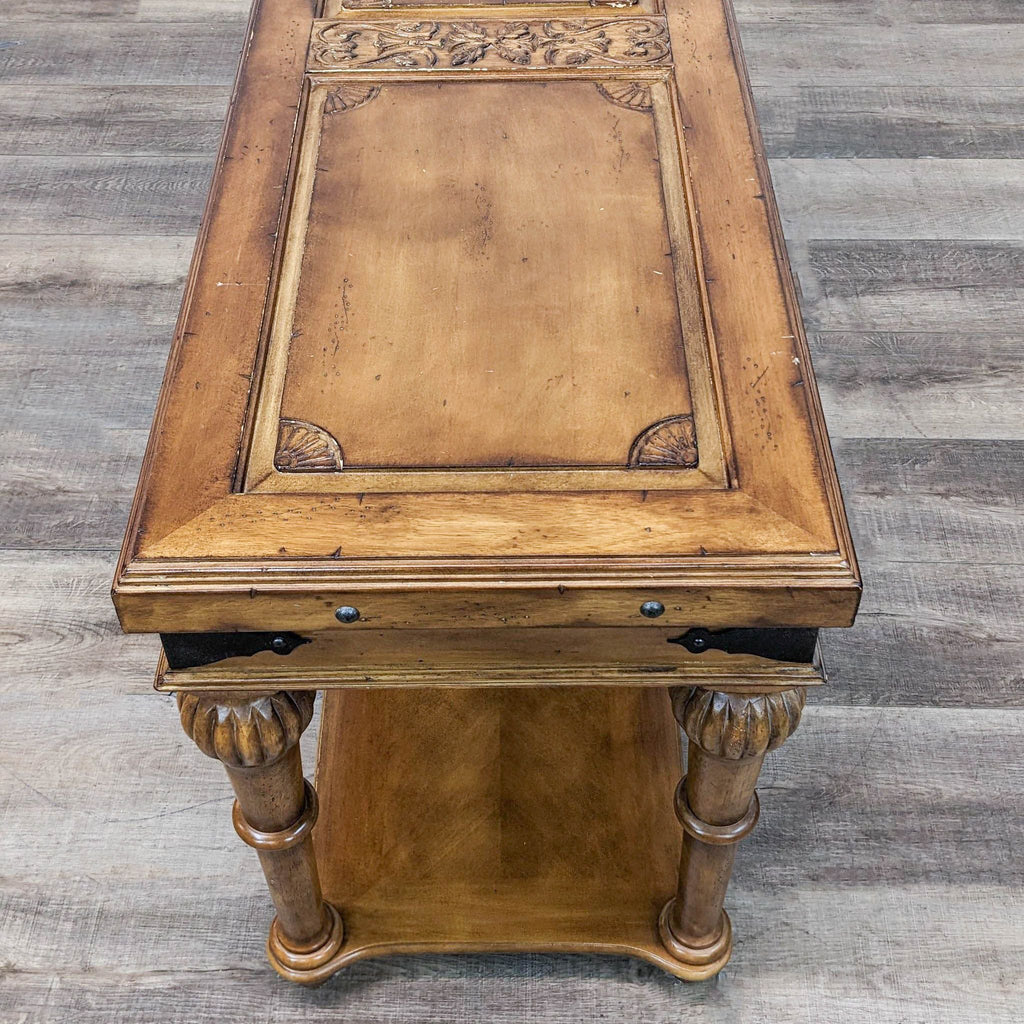 3. Reperch console table with distinctive carved detailing and metal fixtures, photographed from an overhead angle.