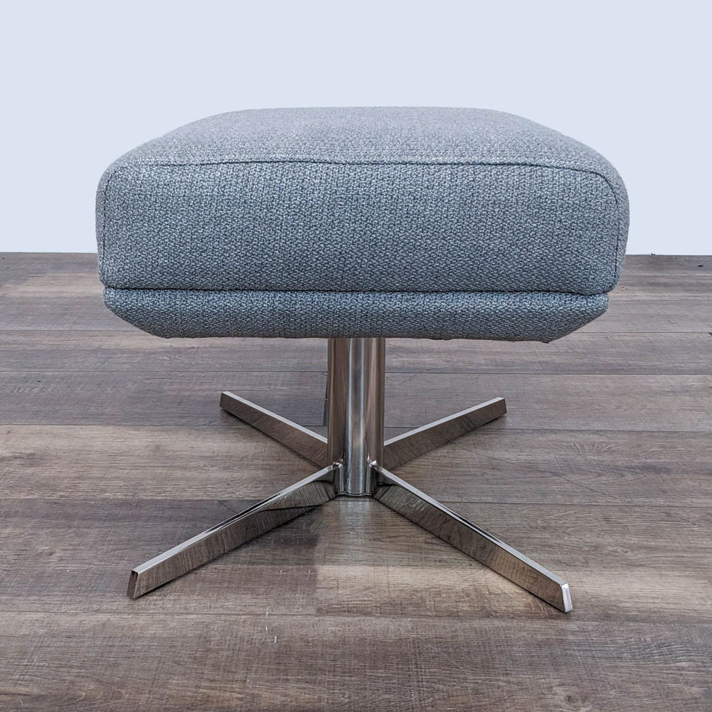 Gray upholstered West Elm ottoman with a swivel metal base displayed on a wooden floor.