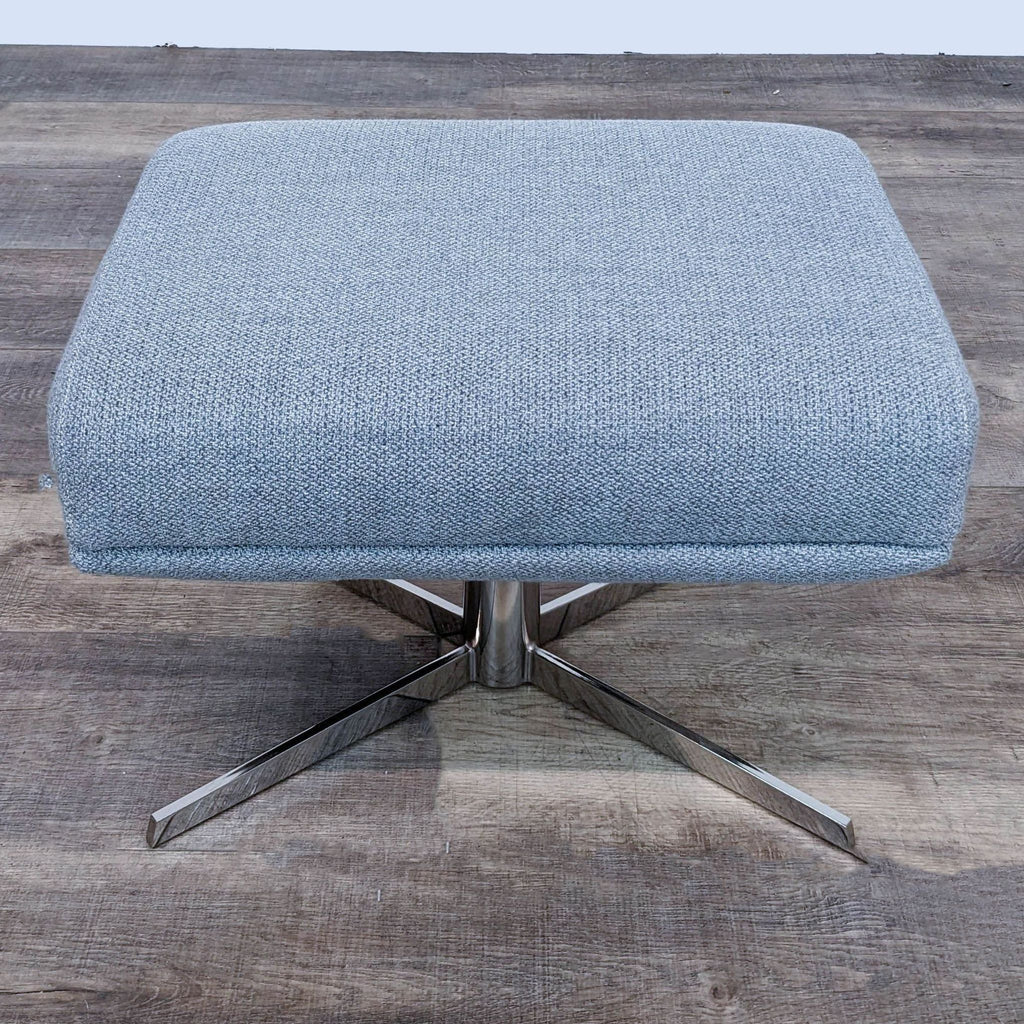 Sleek gray fabric ottoman by West Elm, featuring a sturdy, polished swivel base.