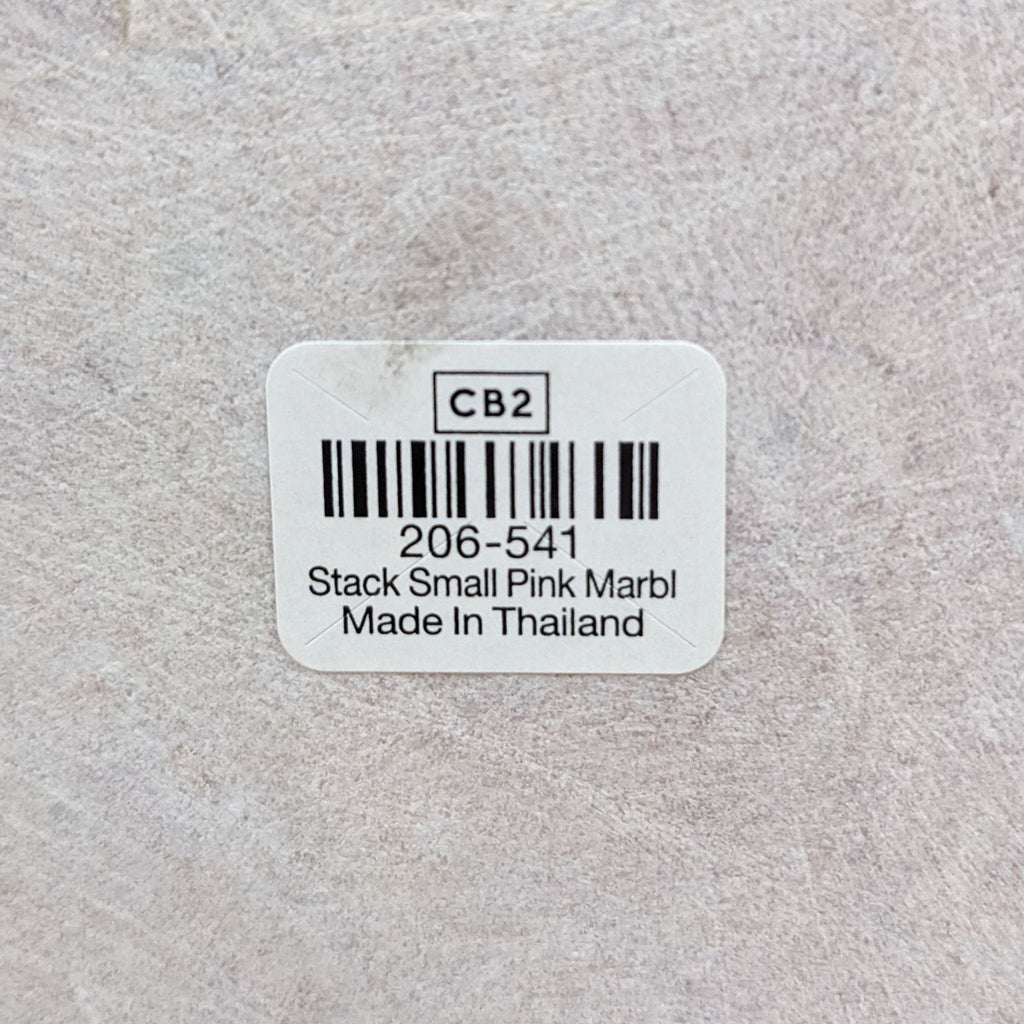 Close-up of product label for CB2 stackable pink marble tray, stating "Made in Thailand."