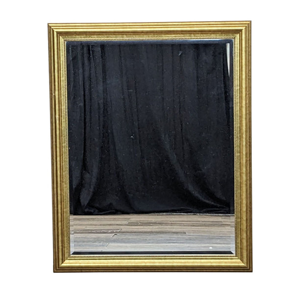 1. IKEA Levanger mirror with an ornate gold frame and beaded trim against a black curtain backdrop.