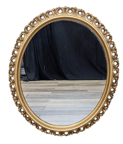 Vintage oval mirror with ornate gold frame by Turner Design.