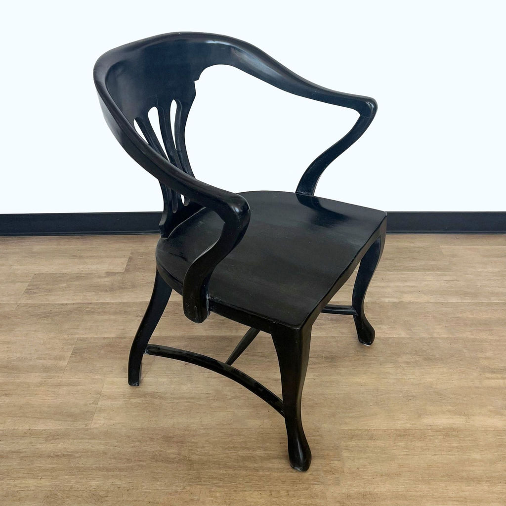 Black lacquered Reperch dining chair with unique curved design, displayed in a room setting with wooden floors.