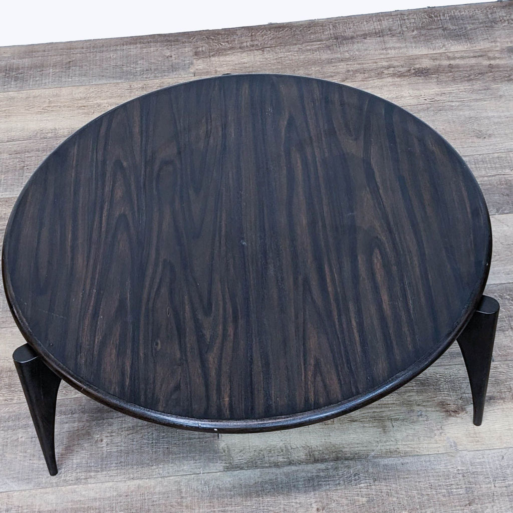 Top view of a circular wood coffee table by Brownstone Furniture, showcasing grain pattern.