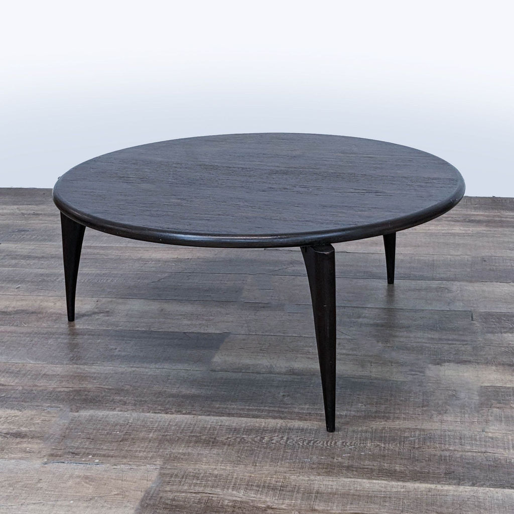 Elegant, round coffee table from Brownstone Furniture, positioned on hardwood flooring, with dark stain.