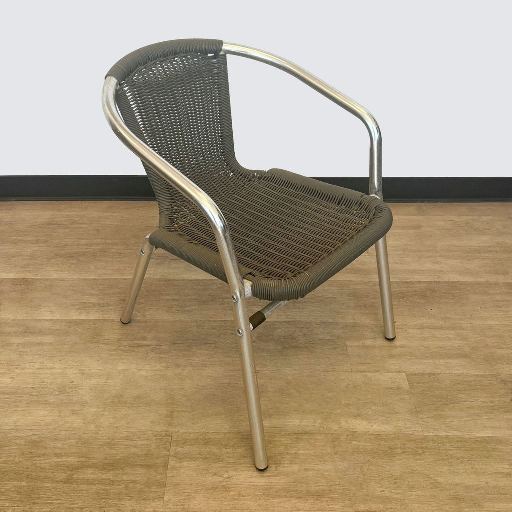 Dark brown Reperch rattan dining chair with metallic frame on a wood floor and white baseboard.