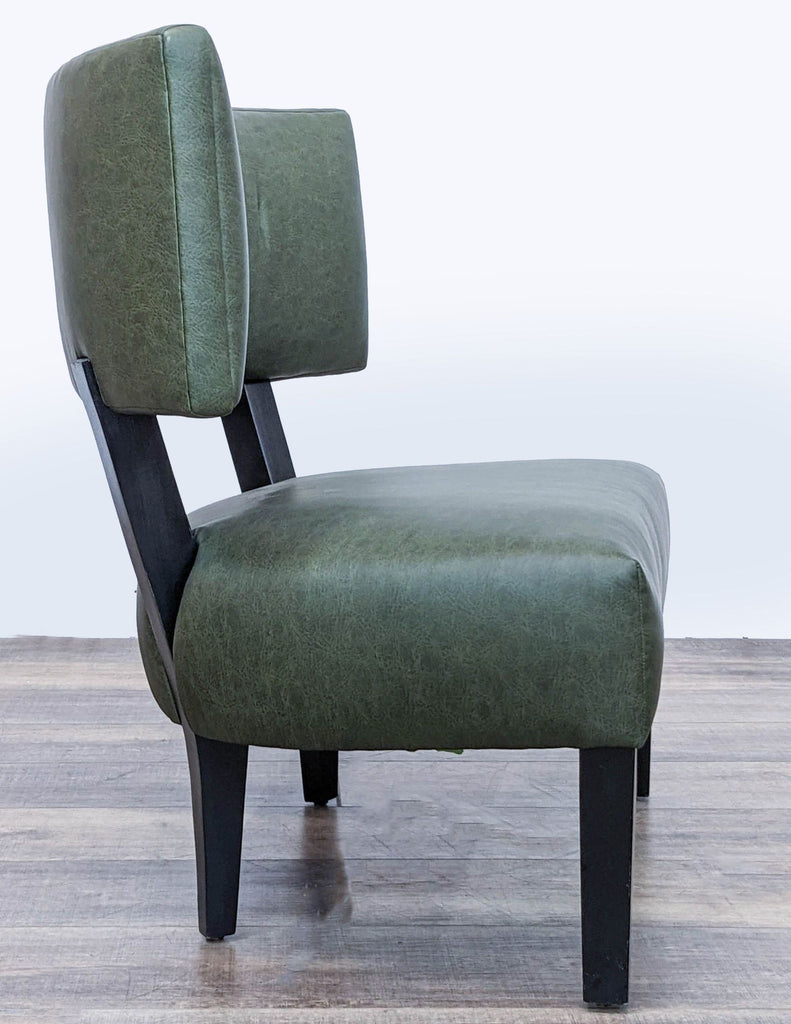2. Side view of a Reperch lounge chair, green faux leather upholstery, and sleek black legs.