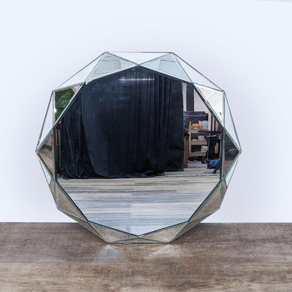 Octagonal beveled wall mirror by Reperch with reflection of a room, displayed on a wooden floor.