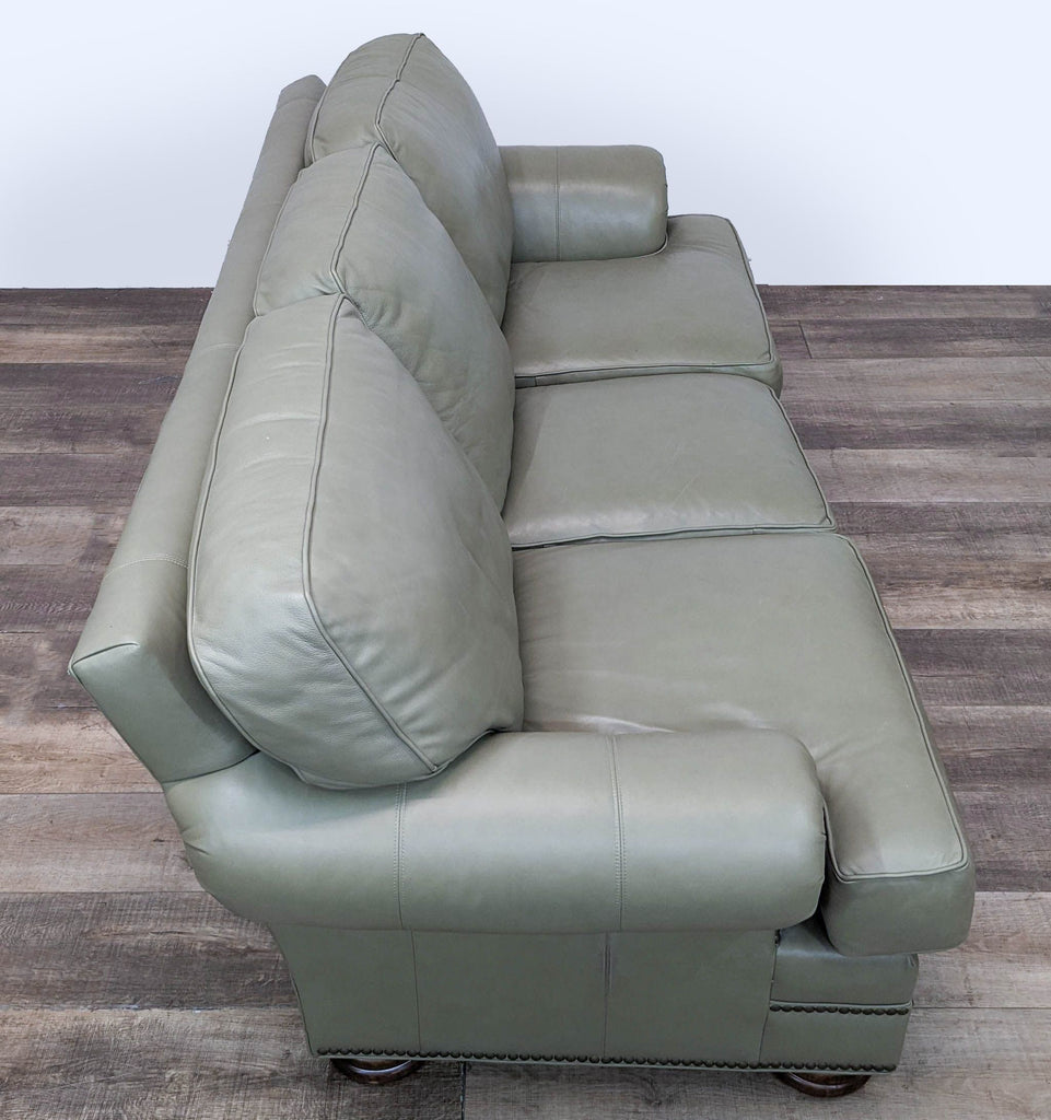 2. Side view of a light green Thomasville 3-seat sofa with decorative nailhead details and wood feet.