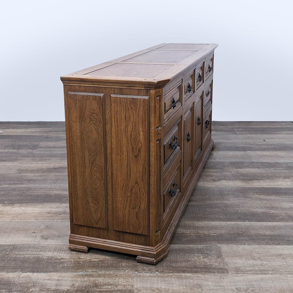 Side view of the Reperch wooden dresser showing the rich finish and detailed craftsmanship, placed on a laminate floor.