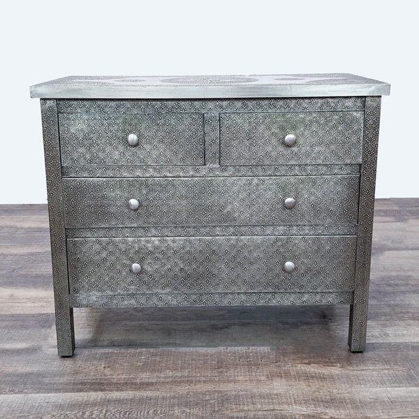 1. Embossed metal-clad dresser with mango wood frame and four drawers by Cost Plus World Market, displayed against a wooden floor.