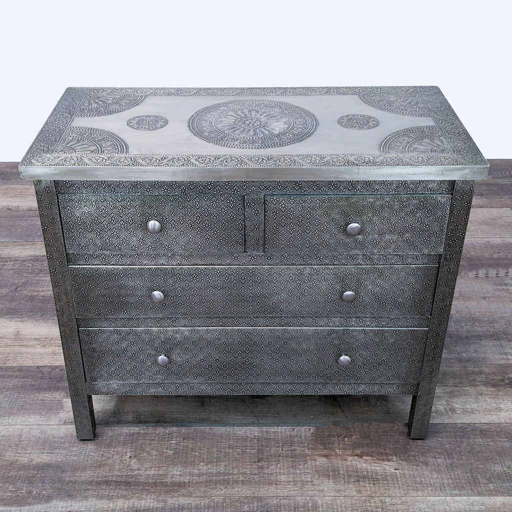 2. Top-down view of a Kiran dresser with intricate metal embossing and circular patterns on surface, from Cost Plus World Market.