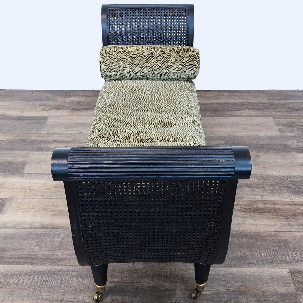 Top-down view of an ornate black and gold Empire bench by Reperch with cane seating and a removable cushion.