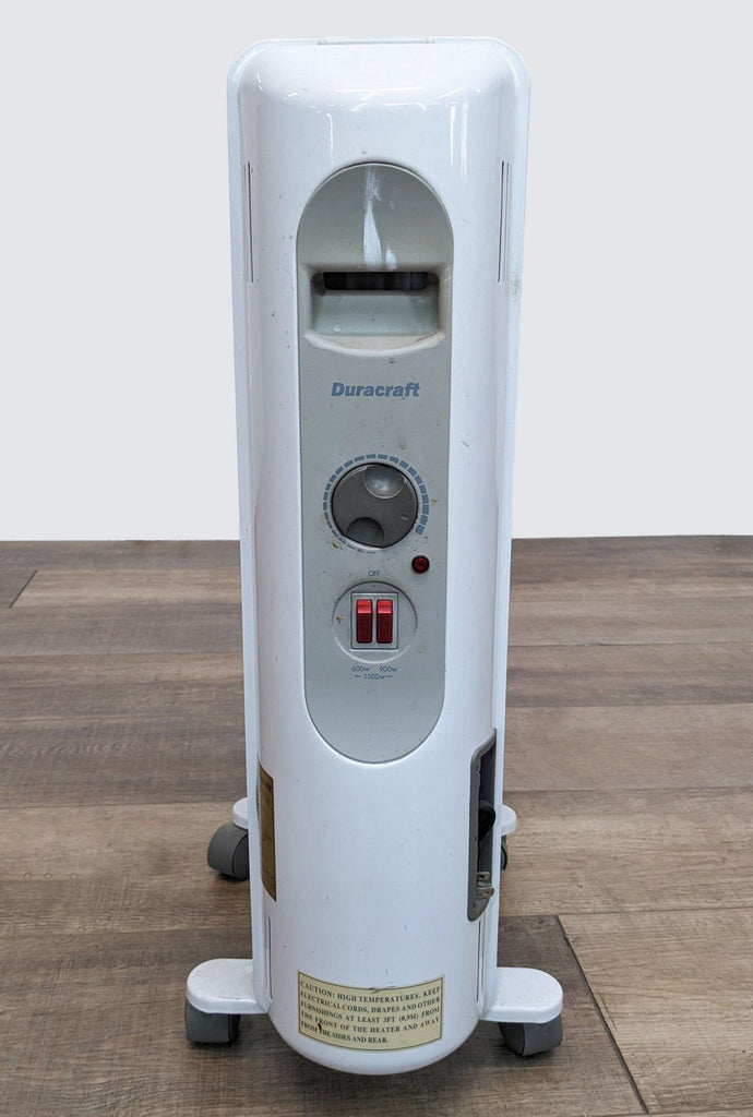 a large white electric heater with a red button on the front.