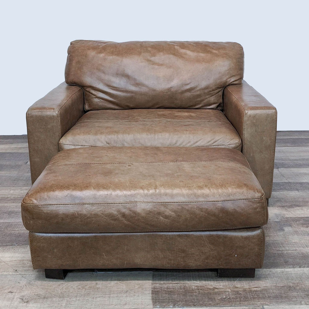 Front view of Jerome's leather lounge chair with a contemporary design, plush cushions, and a separate ottoman.