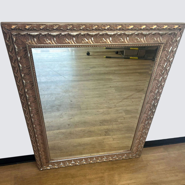 a large antique mirror with a carved wood frame.