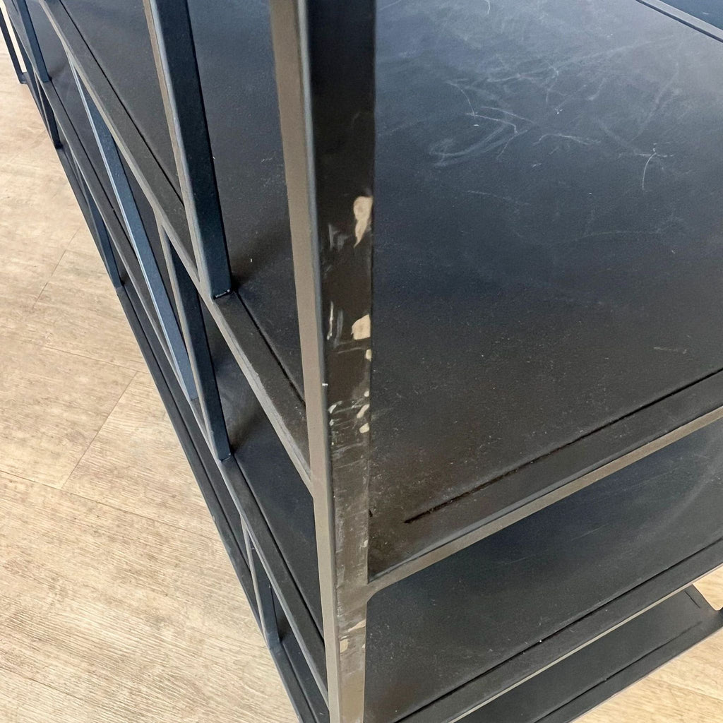 a pair of black metal and glass side tables