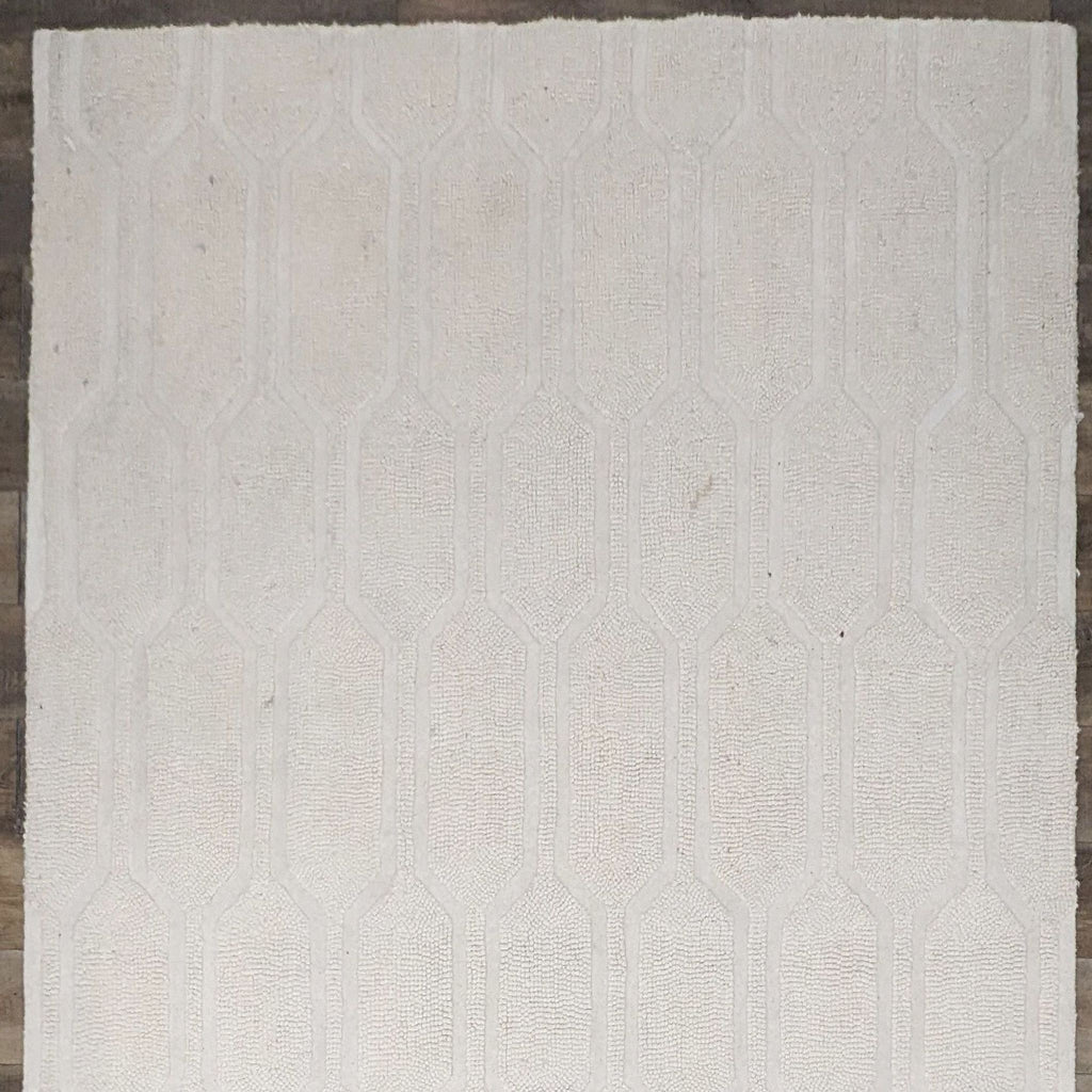 a white rug with a geometric pattern on it.